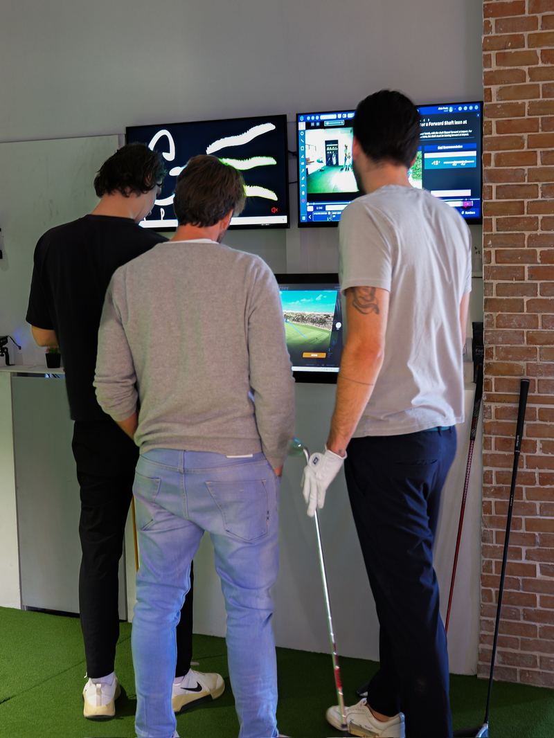 Joueurs devant les écrans d’analyse au G.Spot Golf Marrakech